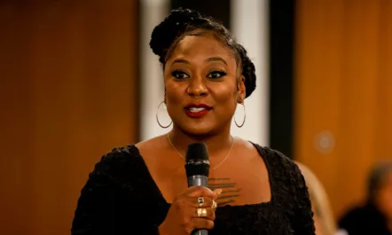 Alicia Garza speaking into a mic at the Women Of Color Leadership Dinner