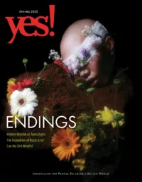 The cover of YES! Magazine's "Endings" issue for Spring 2023. Against a black background, a blindfolded, bald head is shown with the face resting on a pile of dirt. From the dirt emerge yellow, red, white, and orange flowers. The conceptual cover was photographed by Arjuna Asa, an artist from Jakarta, Indonesia.