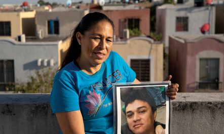 Above her home in Juarez, Nuevo León, Mexico, Elva Rivas holds a portrait of her husband, Roberto Maciel Ramírez, who disappeared in 2010.