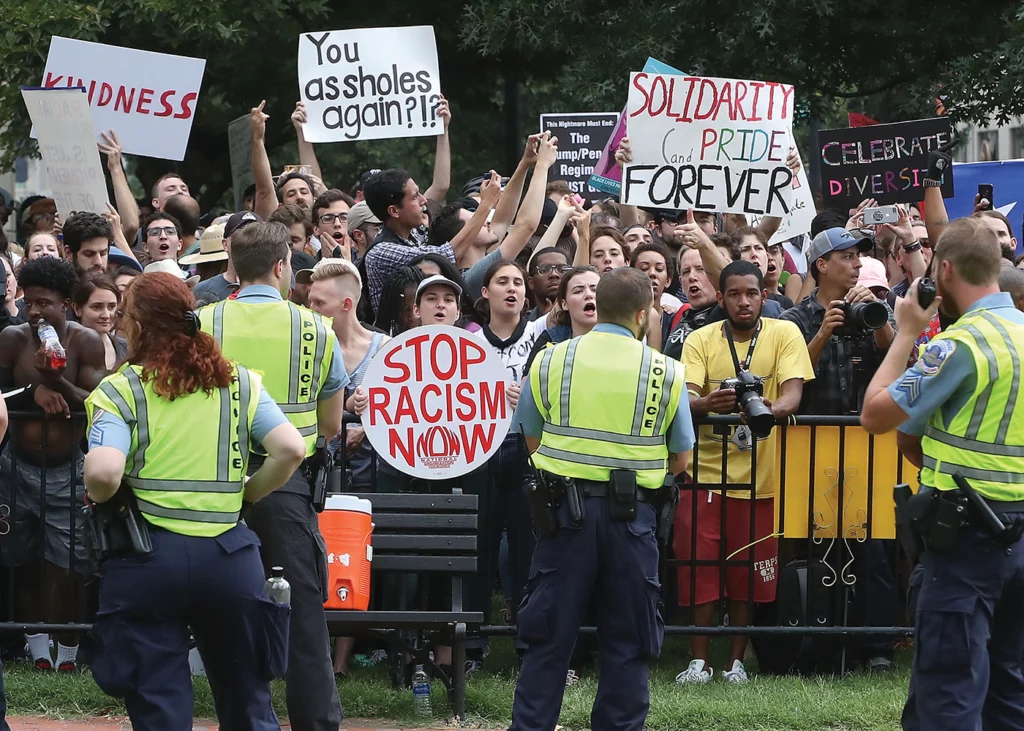 Counterprotestors gather to oppose the "Unite the Right 2" rally. Signs held by counterprotestors read "stop racism now," "solidarity and pride forever," "celebrate diversity," "kindness" and "you assholes again?!"
