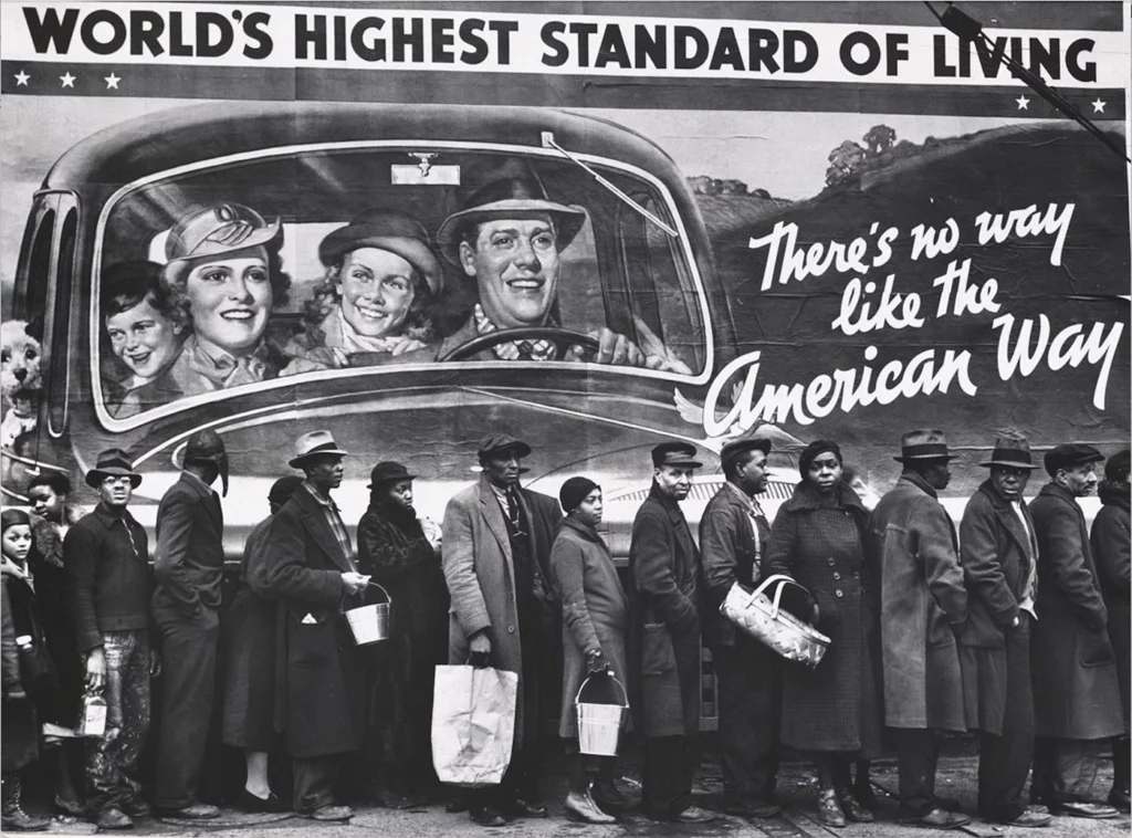 Black residents of Louisville, Kentucky, are lined up seeking assistance in the wake of a catastrophic flood, below a National Association of Manufacturers billboard that depicts a happy white family enjoying “the world’s highest standard of living.” Additional text on the billboard reads "There's no way like the American way."