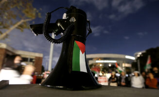 A photo of student protests, detail on megaphone with the Palestinian flag over it.