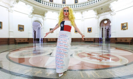 Standing in the rotunda of the Texas State Capitol in Austin, Brigitte Bandit shows the gown she wore—bearing the names of children killed in recent mass shootings in Uvalde and Allen, Texas—to testify against S.B. 12, which would have criminalized drag performances. In her testimony, she accused Texas GOP lawmakers of “spending more time in this legislative session targeting drag queens than gun violence.”