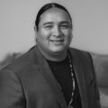 an Indigenous man looks at the camera