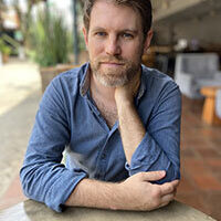 a white man sits at a table