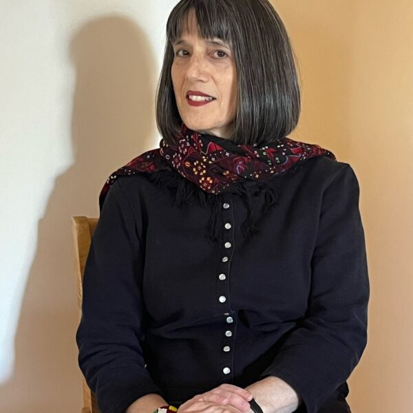 Nancy Kricorian sits on a chair with a coat on