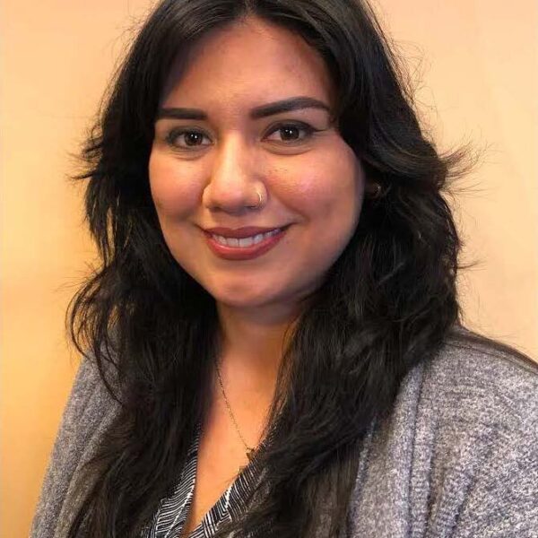 Vanessa Godinez is a woman with long hair and a gray blazer on