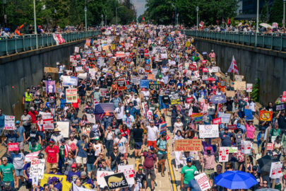 A vast number of people march in Washington, D.C., carrying signs in protest of the Trump Administration