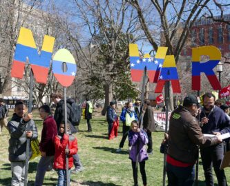 Demonstrators, including youths, hold signs that read 'No War', painted in the colors of the Venezuelan flag.