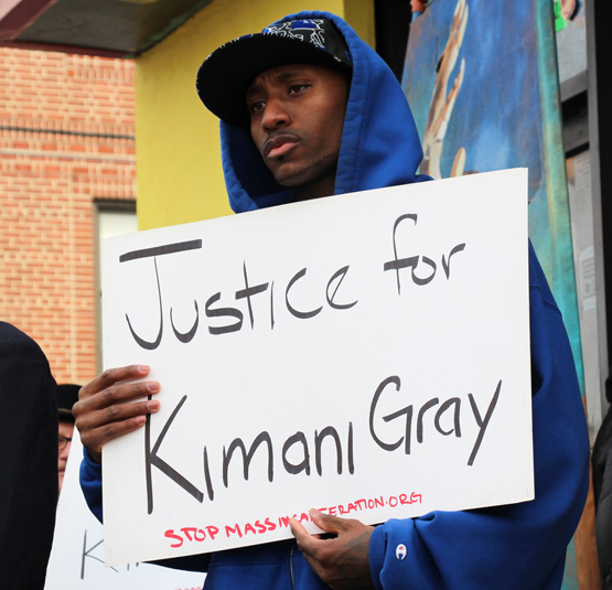 Man with Sign that reads “Justice for Kimani Gray”