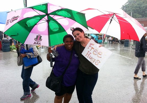Volunteer giving a free hug at the Ferguson Farmers Market. Photo courtesy of Molly Rockamann.