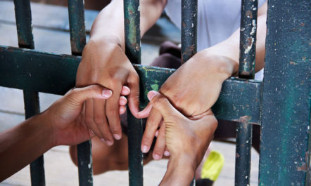 Hands Behind Bars photo from Shutterstock