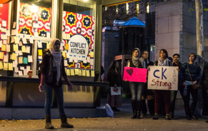 Woman speaking at Conflict Kitchen by Heather Kresge