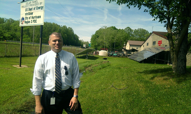 Ben Newhouse with solar array. Photo by Mary Hansen.